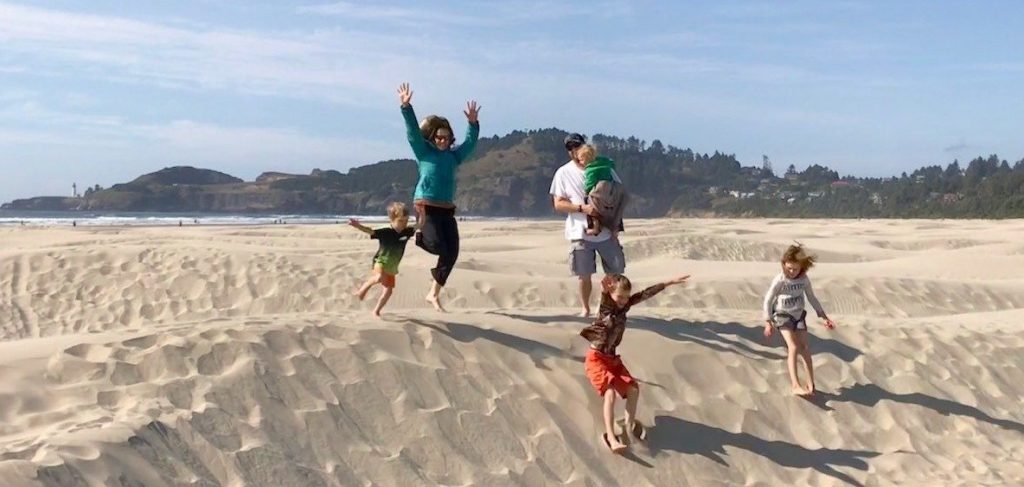 Kids and family jumping in the sand on agate beach on Oregon coast - Fun family friendly beaches on Oregon coast- Oregon Coast-Oregon State Parks- Road Trip Pacific Northwest- beaches pacific northwest- best Oregon Coast beaches for families - kid friendly beaches on Oregon Coast- beach hopping Oregon coast- Fun things to do on Oregon Coast with kids