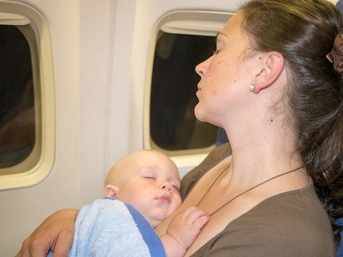 Mother and lap infant sleeping on a flight together