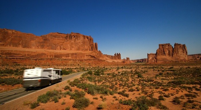 Summer vacation travelers tour through Arches National Park in Utah USA. RV camping in Moab Area