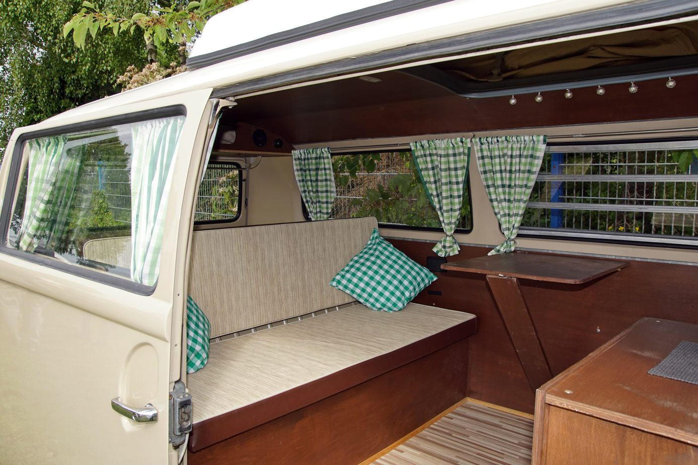 A sofa like set up with curtain windows inside a van