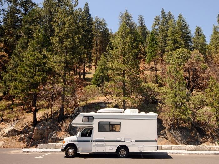 Class b motorhome parked on a road side trees
