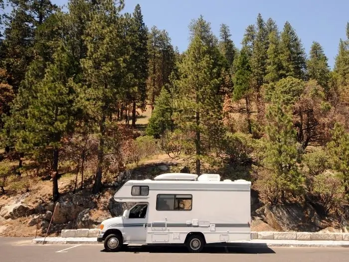Class b motorhome parked on a road side trees
