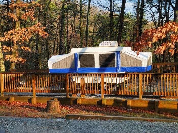 A pop up camper parked in the middle of the woods
