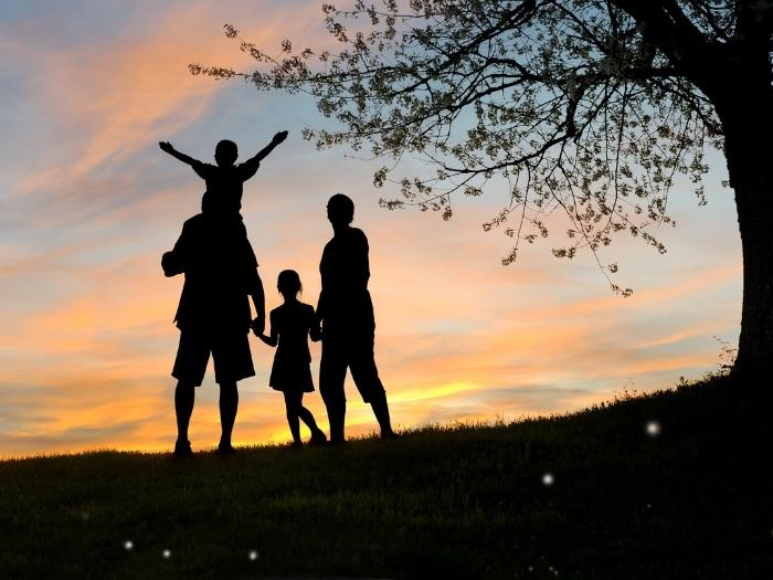 Family silhouette with a tree background