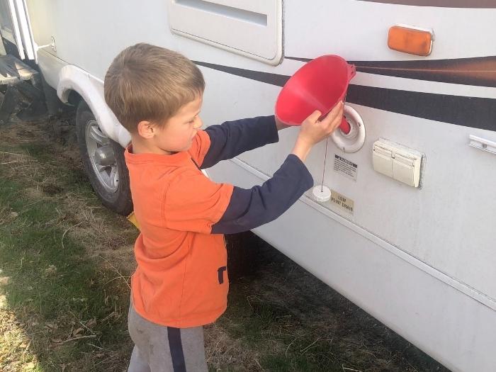 A child readying a funnel for pouring antifreeze chemical