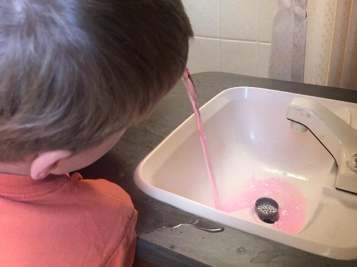 A child filling the sink with antifreeze chemical