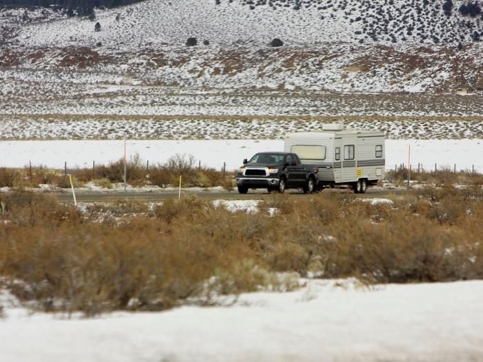 Travel trailer pulled by a pick up on a snowy road