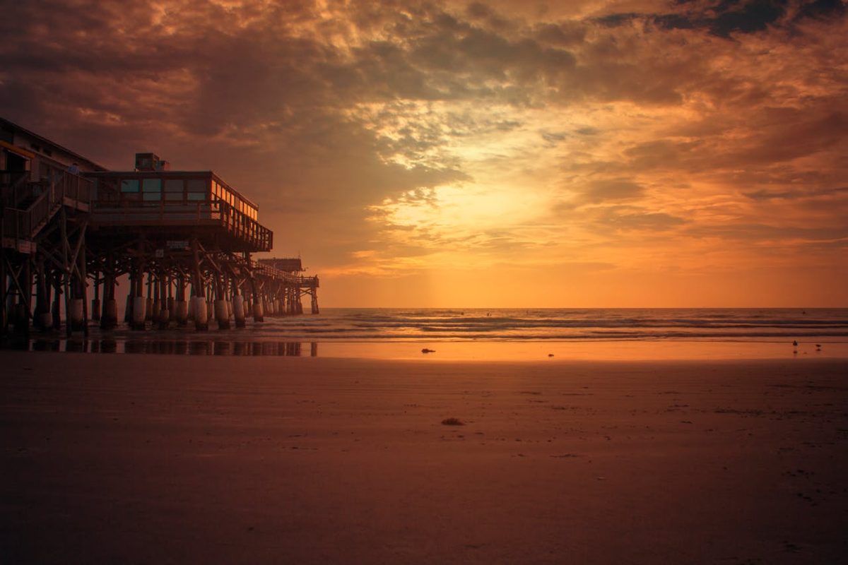 Cocoa Beach Pier stretching into the Atlantic Ocean at sunset in Florida