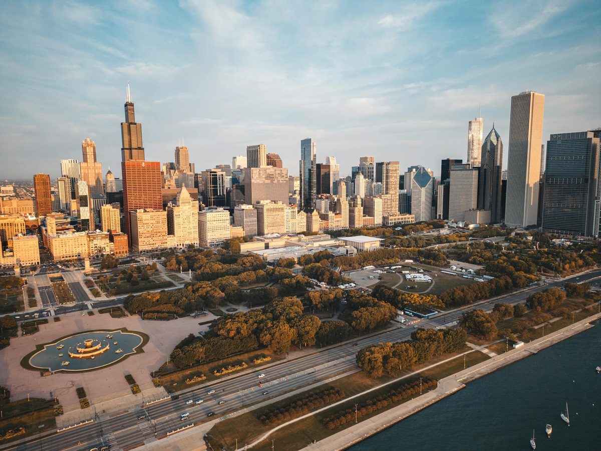 Aerial view of the Chicago skyline with the Lake Michigan shoreline curving into the distance at dusk