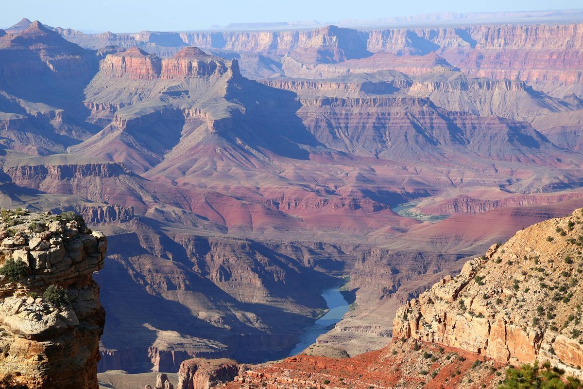 Panoramic view of the Grand Canyon showing layered red and orange rock formations stretching to the horizon