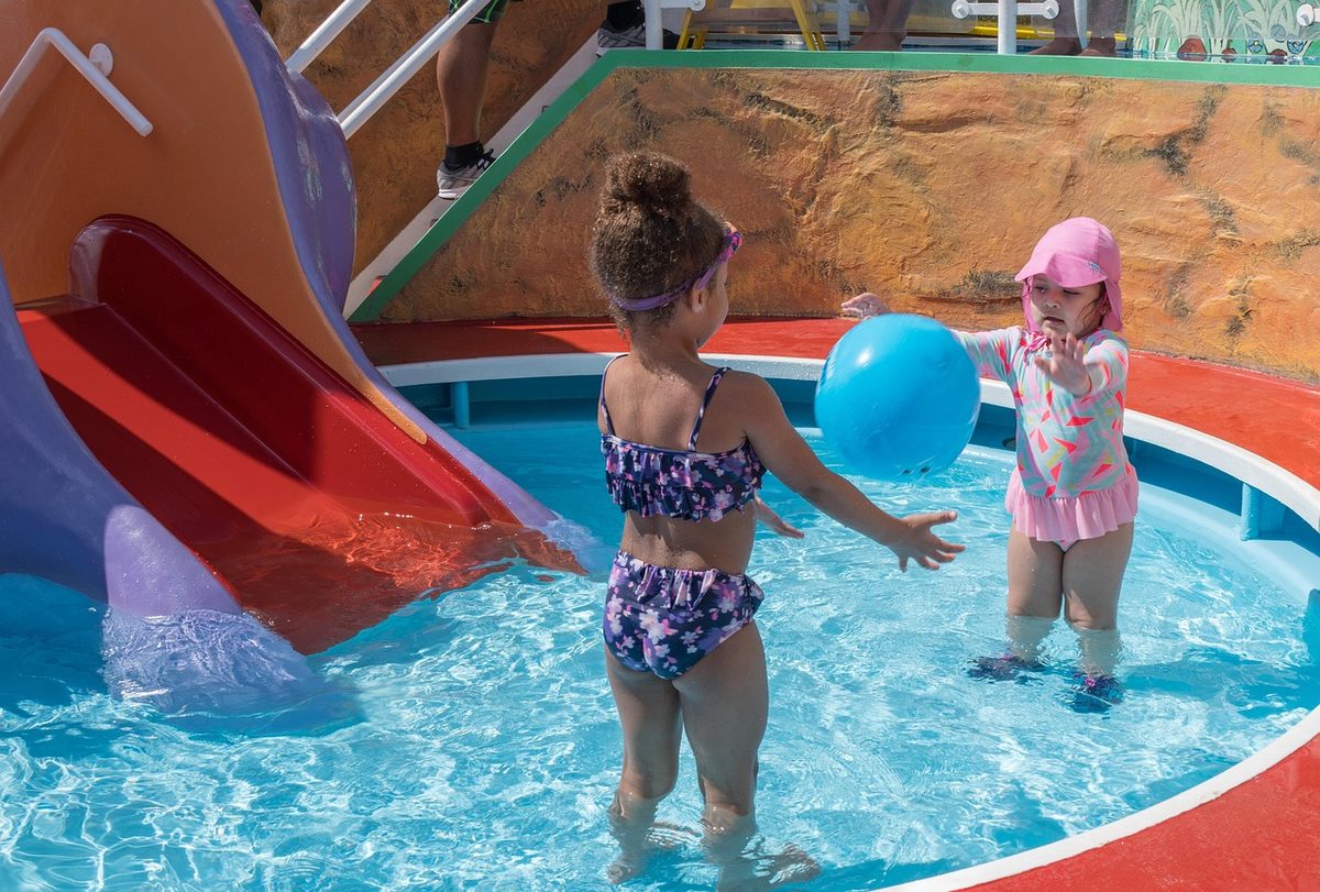 Kids playing and splashing in a water park pool