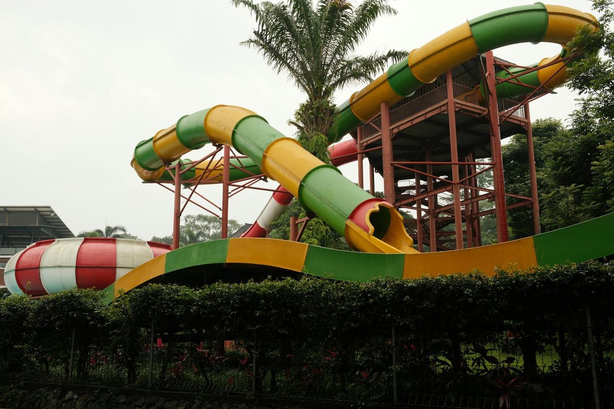 Colorful water slides at a water park with bright red, green and yellow sections