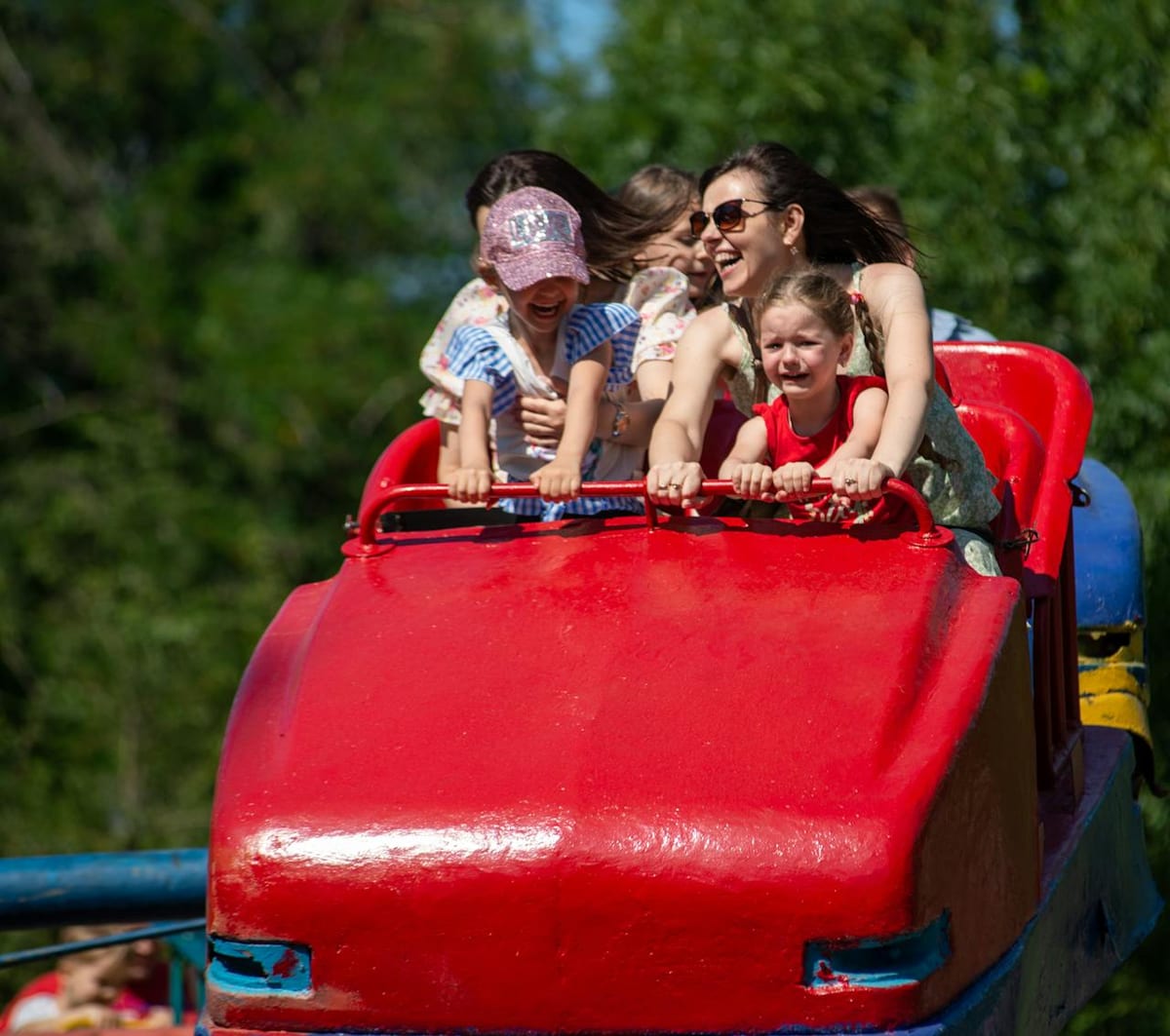Family enjoying a theme park roller coaster ride together