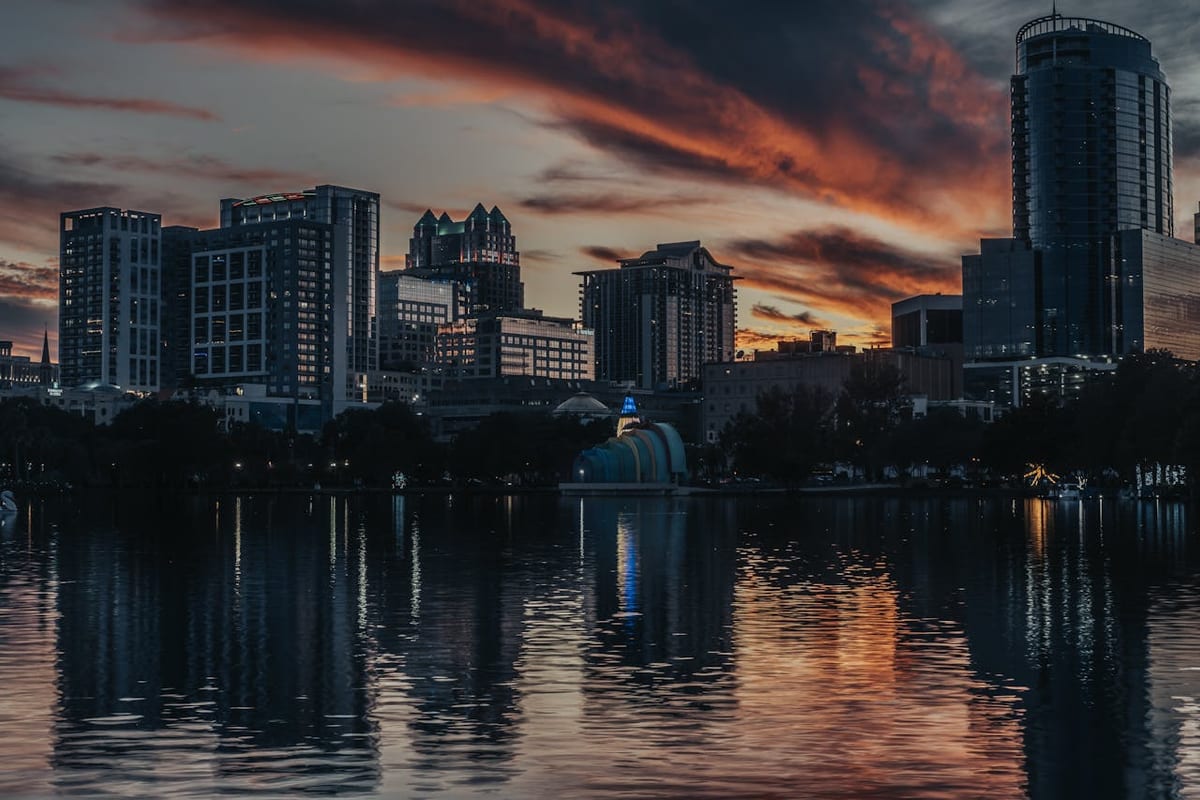 Orlando Florida city skyline illuminated at dusk reflecting on a lake