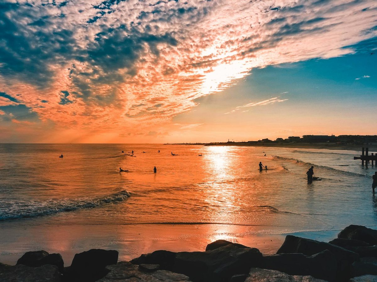 Colorful sunset over Cape May beach with waves gently lapping the shore