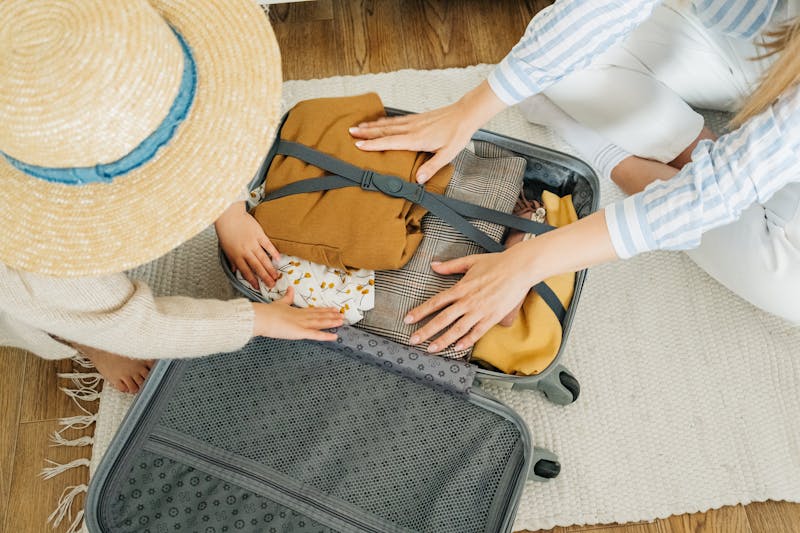 Mother and child packing clothes into a suitcase for a family trip to Japan