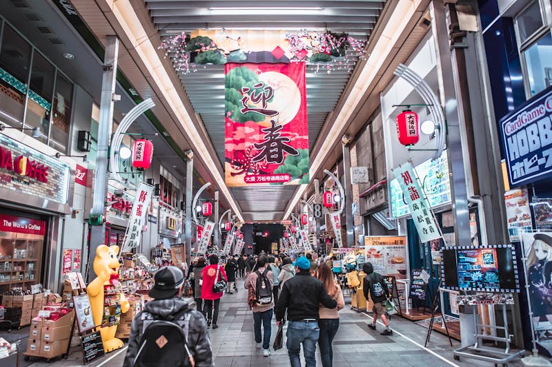 Bustling covered shopping arcade in Japan with diverse shops and people