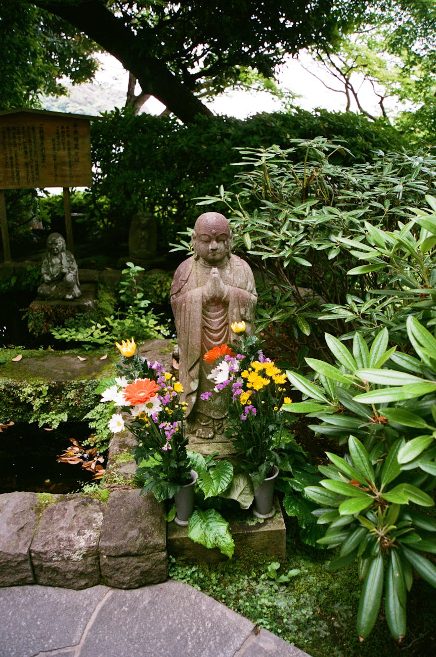 Peaceful Buddha statue surrounded by flowers at Hase-dera Temple in Kamakura