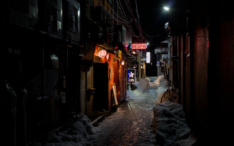Historic snowy alley in Kanazawa Japan with lanterns at night