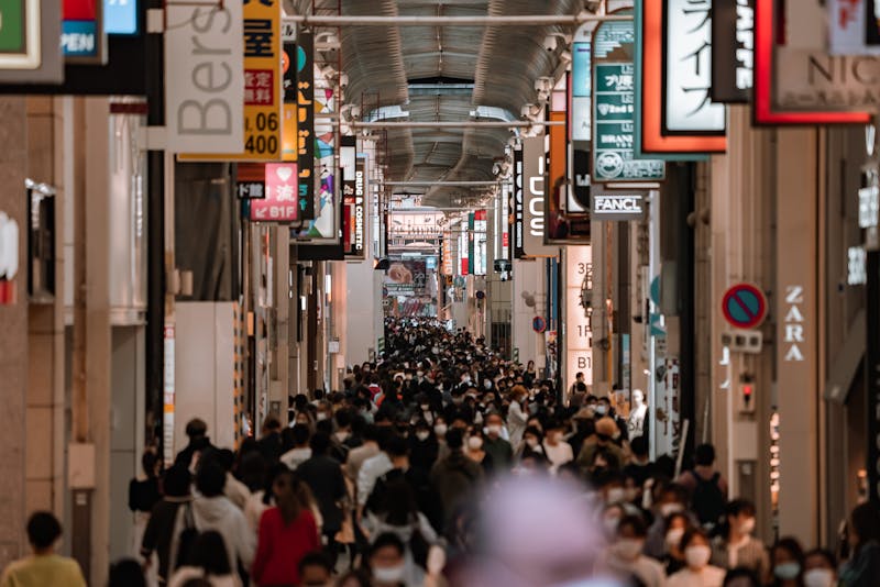 Busy indoor shopping arcade in Osaka with bright store signs