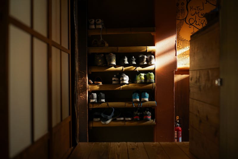 Shoes neatly organized on a rack at the entrance of a traditional Kyoto home