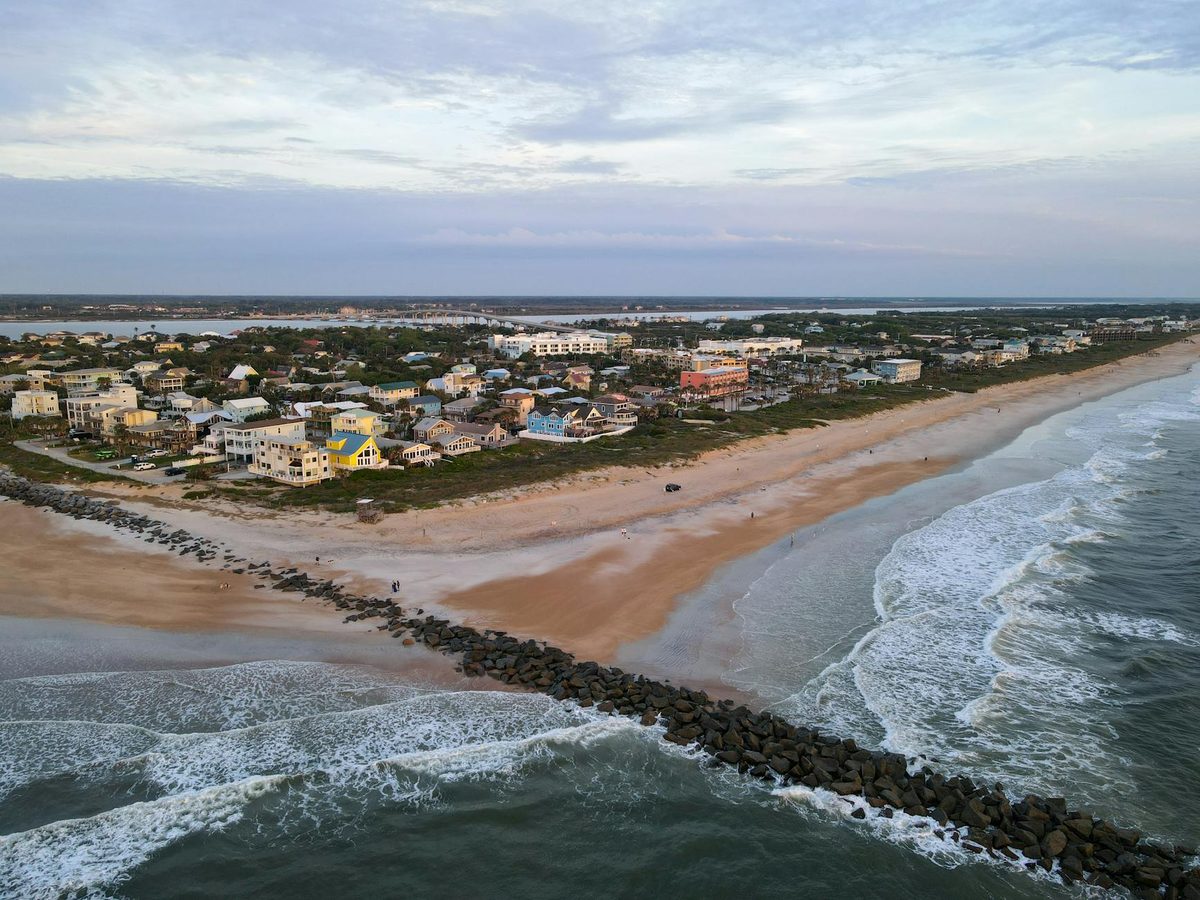Aerial view of St. Augustine Beach with waves rolling in along the wide sandy coastline