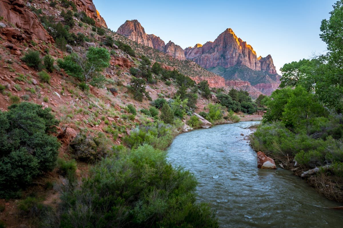 Dramatic canyon walls and the Virgin River at sunset in Zion National Park