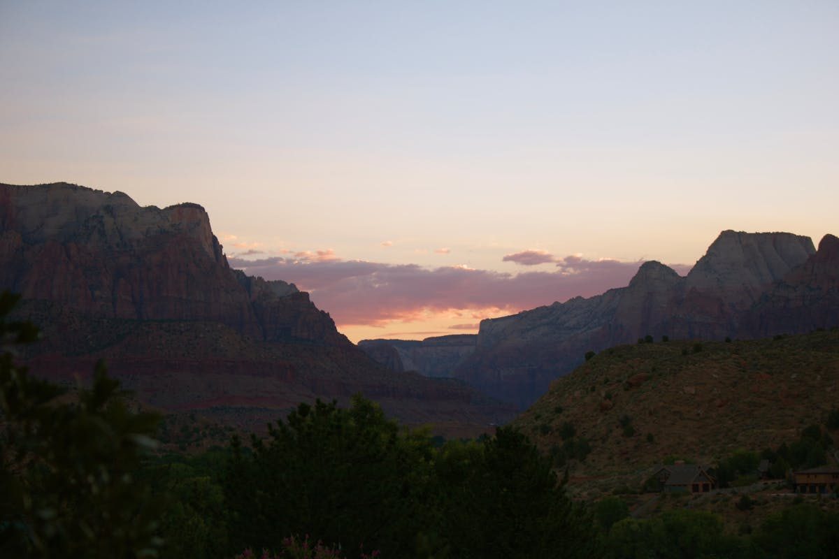 Sunset casting warm light over canyon cliffs at Zion National Park