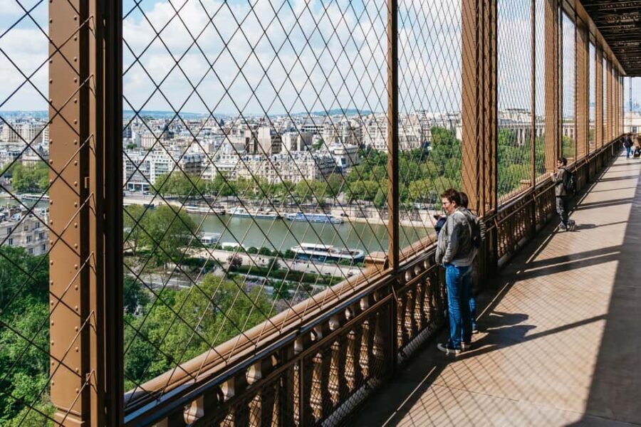 Paris: Eiffel Tower Fully Guided Tour with Summit Option - Base-to-2nd-floor flow: security, elevators, and a guide with a story